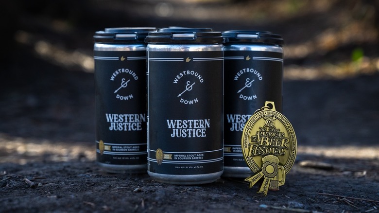 Three cans of Westbound & Down Western justice beer and a gold medal from The Great American Beer Festival