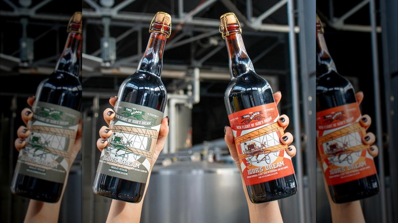 Two hands holding two beer bottles