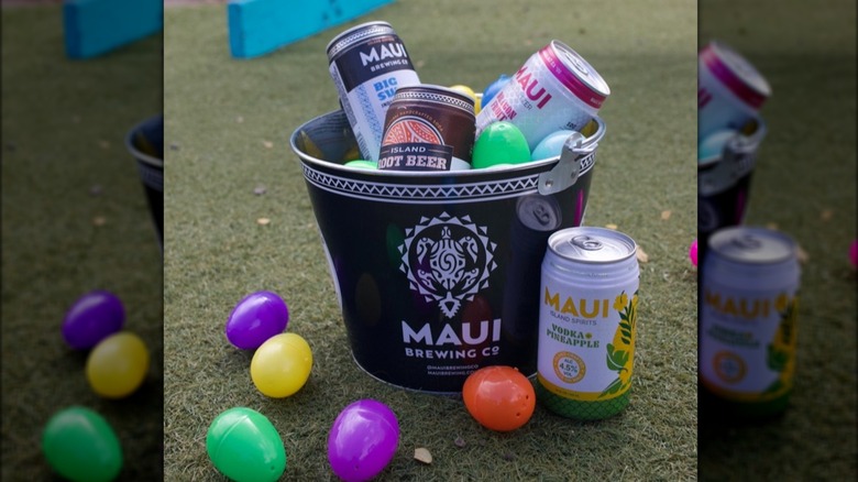 Maui Brewing Co. beer and cocktail cans on a Maui Brewing bucket alongside Easter eggs of different colors
