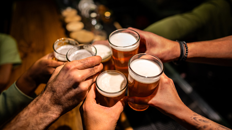 Close up of friends toasting with beer