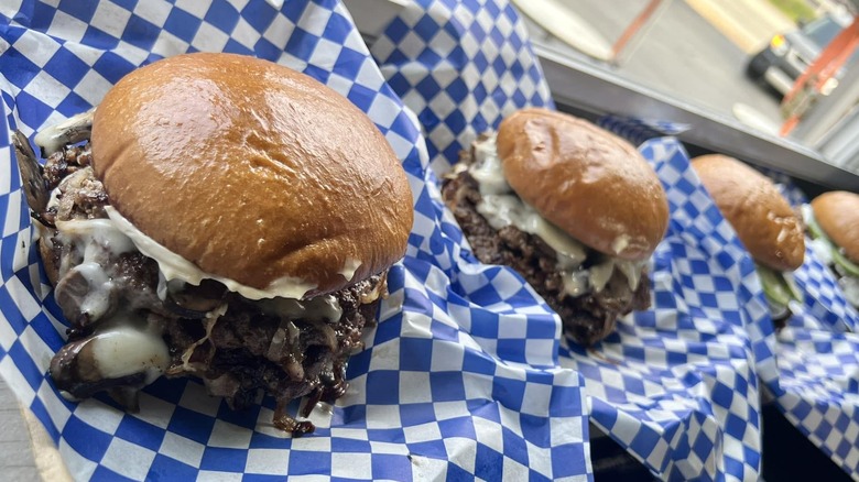 four double cheeseburgers on checked paper in baskets