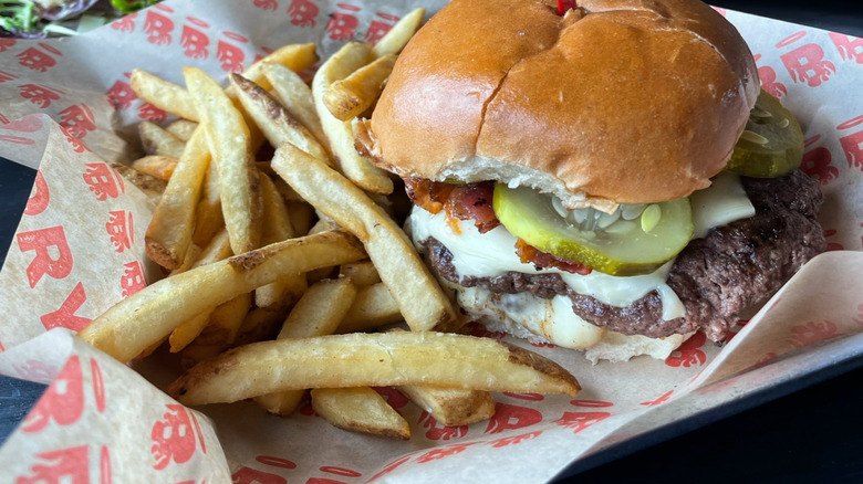 Cheeseburger with pickles and bacon with fries
