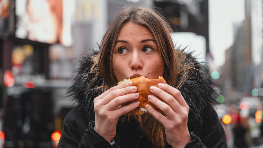 Woman in New York eating burger