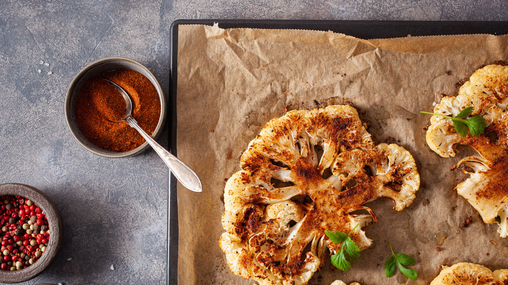 cauliflower steaks on a tray with seasoning rub