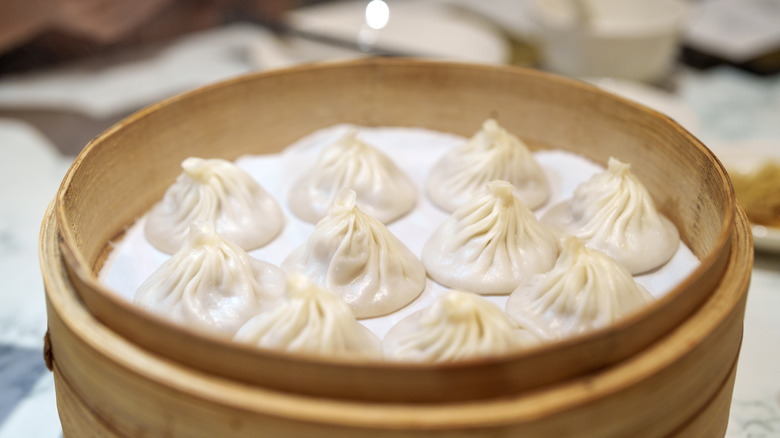 A bamboo steamer basket full of soup dumplings
