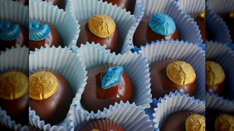 Confection paper cups holding decorative chocolates.