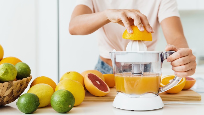 Person juicing citrus fruits