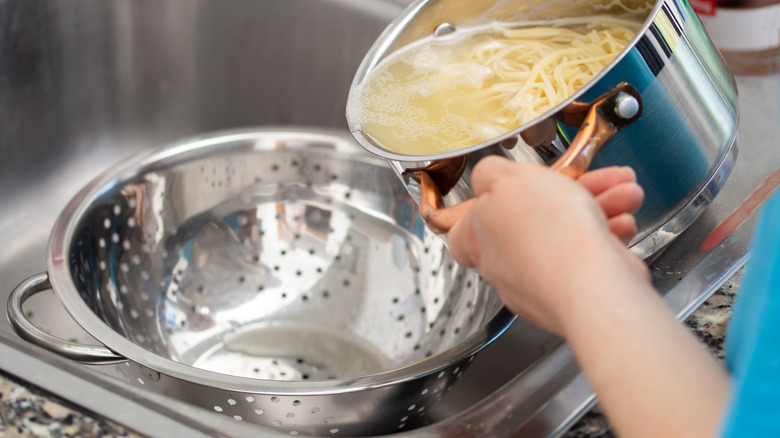 Using colander to drain pasta