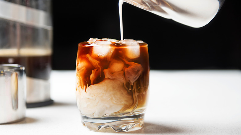 Pouring milk into cold coffee