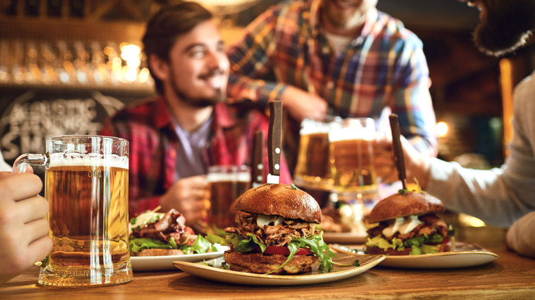 People enjoying beers and burgers at a pub 