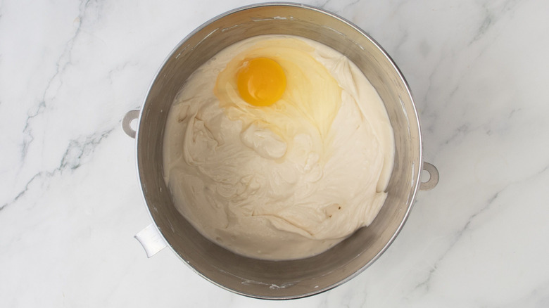Whipped cream cheese and egg in mixing bowl