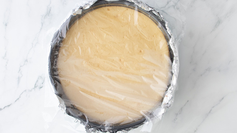 Cheesecake covered in plastic wrap