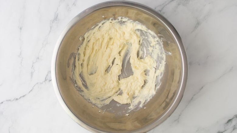 Beaten mascarpone cheese in mixing bowl