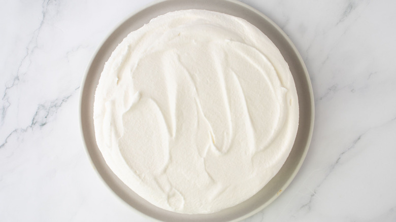 Cheesecake with whipped topping on serving plate