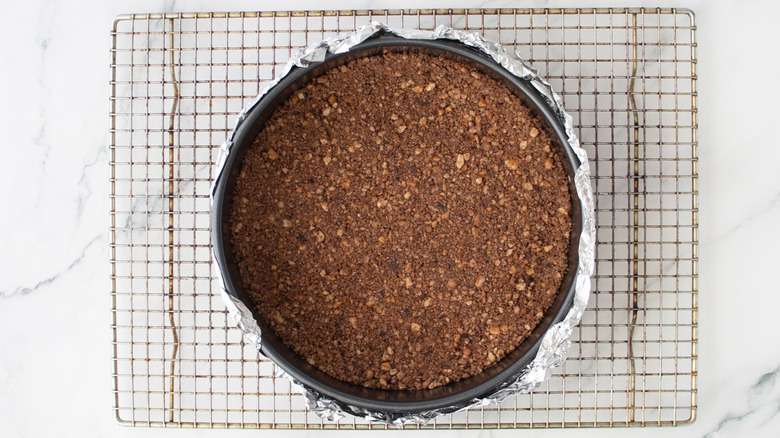 Cheesecake crust in springform pan on wire rack