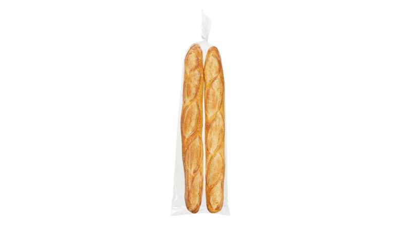 Two baguettes in a clear plastic bag on a white background