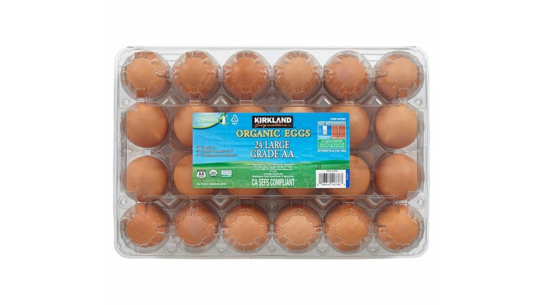 A 24-pack of organic brown eggs in a plastic container on a white background