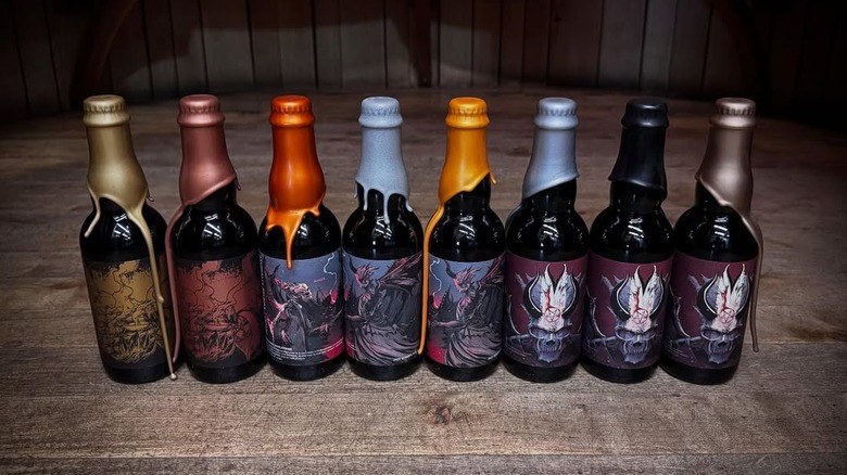 A lineup of wax-dipped Anchorage Brewing bottles sitting on a wooden surface
