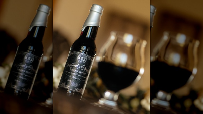 A wax-sealed bottle of Toppling Goliath's Kentucky Brunch Brand Stout stands beside a filled snifter glass.