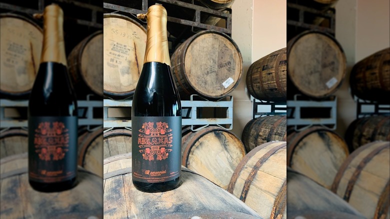 A bottle of BA Abraxas in a barrel room on a wooden barrel.