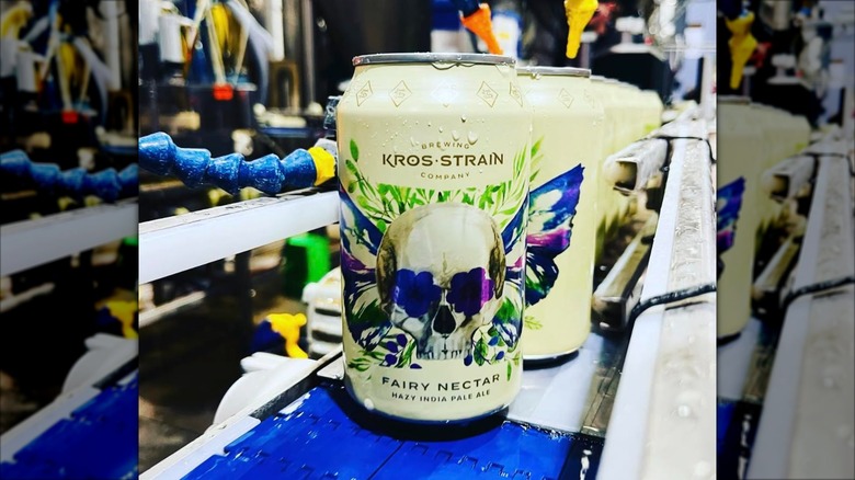 A can of Kros Strain Brewing's Fairy Nectar Hazy IPA on a blue conveyor belt inside the brewery