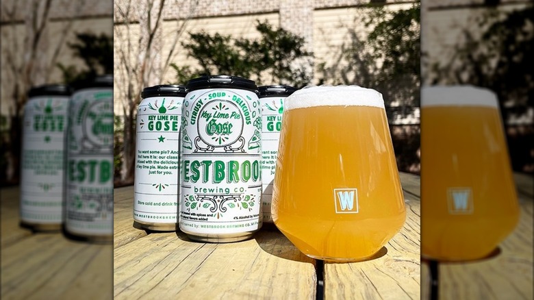 A can of Westbrook's Key Lime Pie Gose next to a glass filled with hazy golden beer and a foamy head