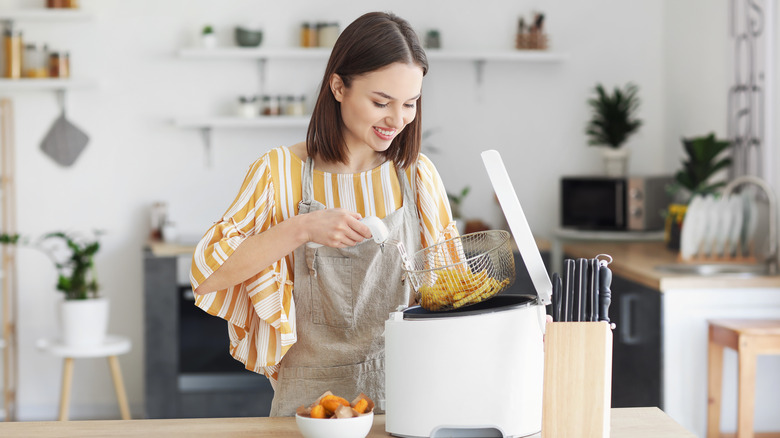 Woman operating a deep fryer