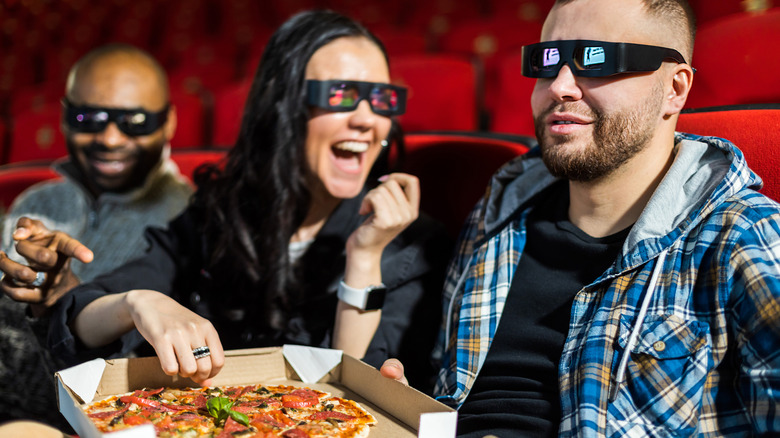 People eating pizza at movie theater