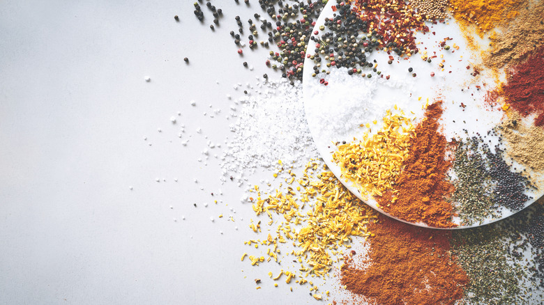 Mix of dried spices spilling over the edge of a white plate