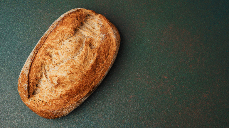 A loaf of homemade bread on a dark green background