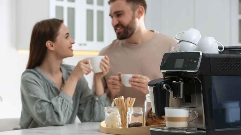 Smiling couple with espresso/cappuccino machine