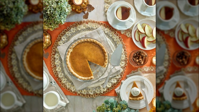 Seasonal table decorated with orange cloth, green hydrangea, and pumpkin pie