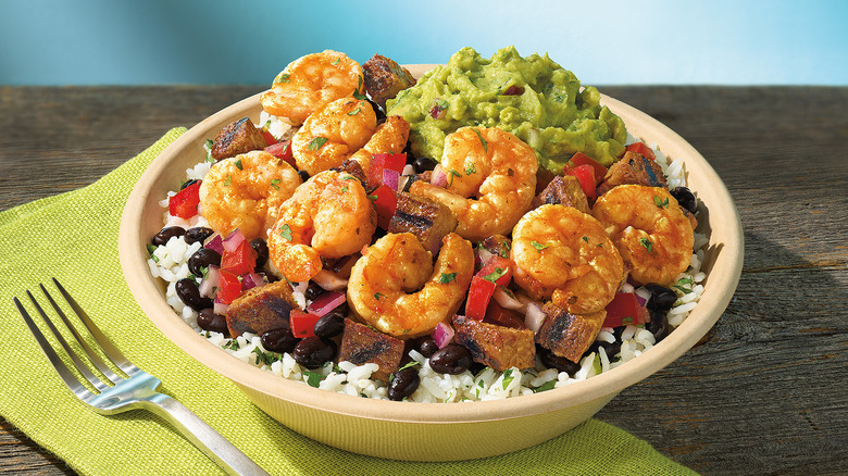 Qdoba Citrus Lime Shrimp in bowl with guacamole, black beans, white rice and veggies
