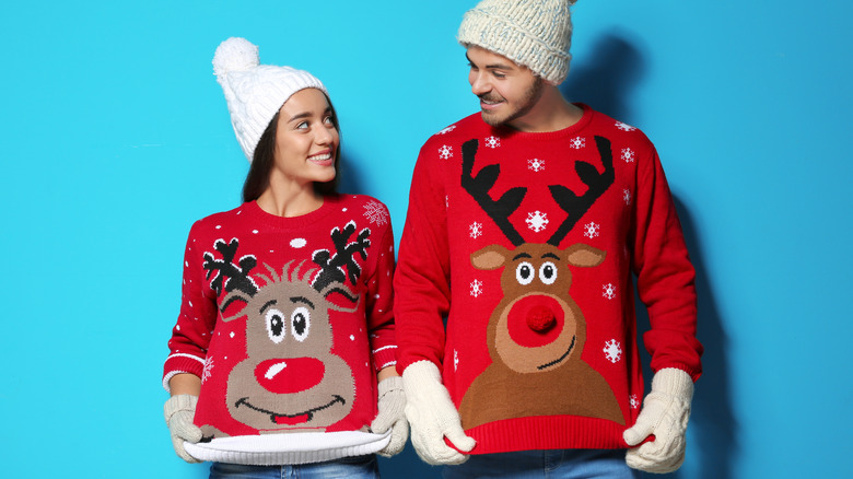 Couple wearing ugly holiday sweaters 