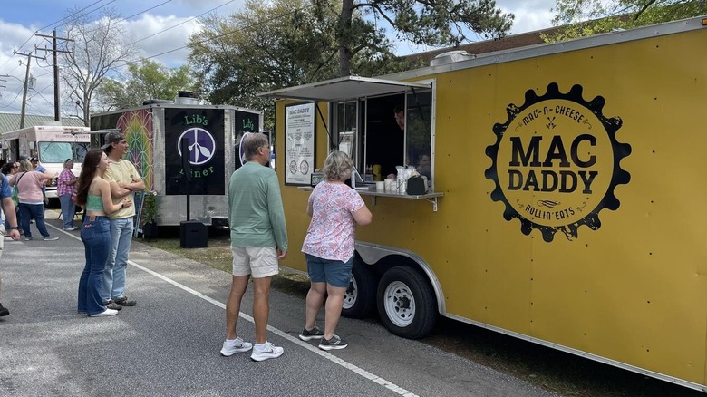 Customers at window of yellow Mac Daddy food truck