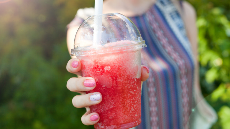holding frozen red drink