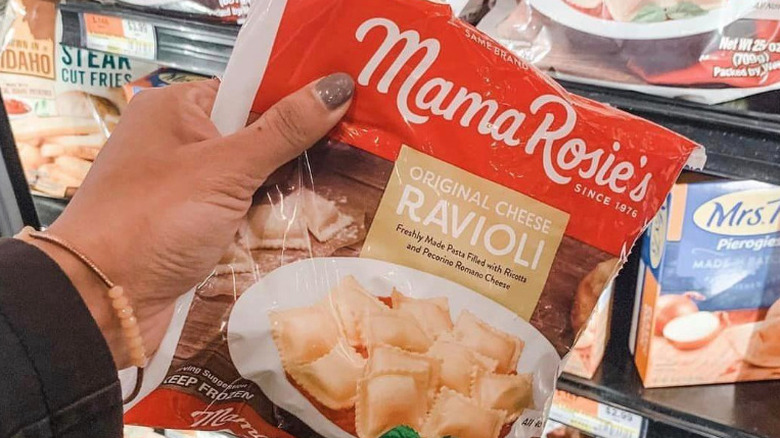 Hand taking Mama Rosie's ravioli from freezer case