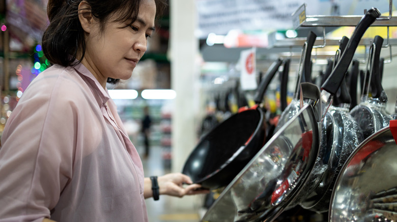 Woman shopping for frying pans
