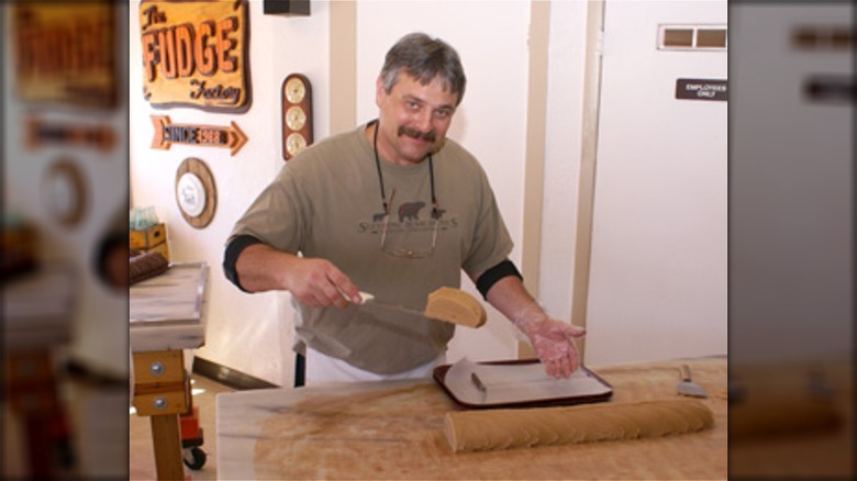 Man lifting slice of fudge on spatula at The Fudge Factory in Florida