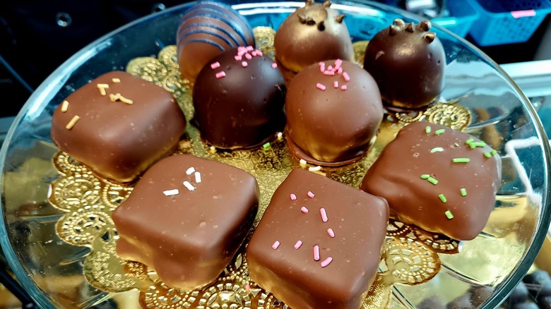 Assorted chocolate-covered fudge and truffles on a tray