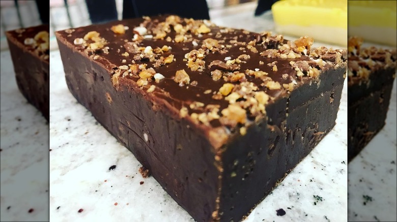 Loaf of nut-topped fudge on marble counter at Cowtown Candy Company
