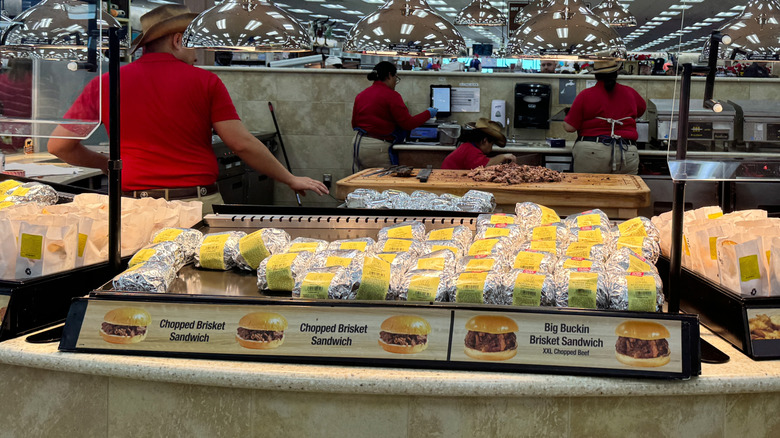 Buc-ee's brisket sandwiches with employees preparing sandwiches in background