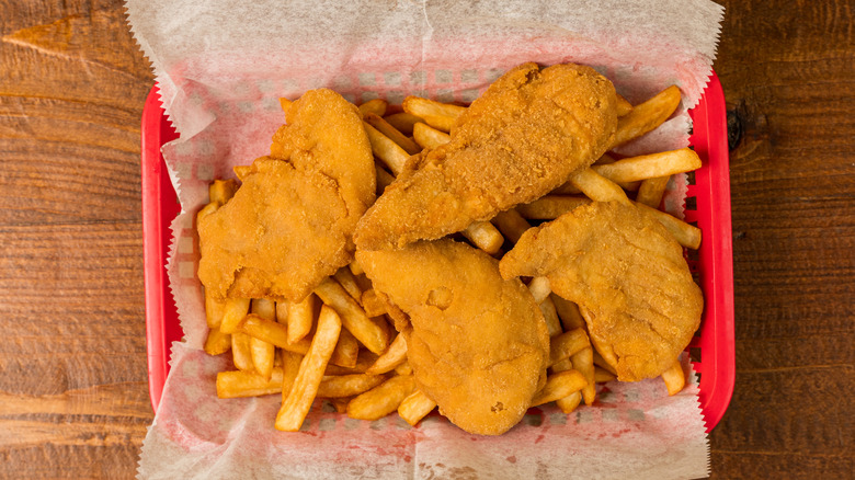 chicken tenders and fries in a red tray