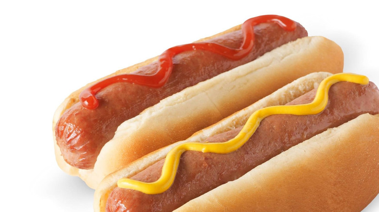 Two RaceTrac hot dogs with ketchup and mustard on white background