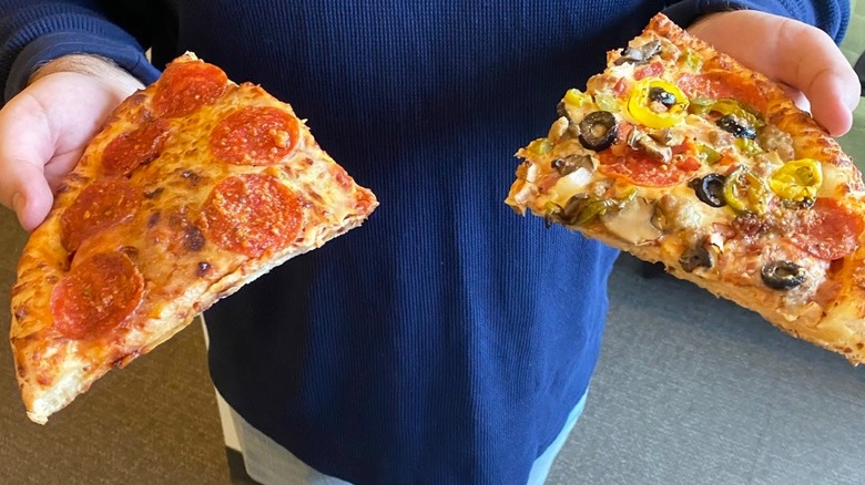 person holding Hunt Brothers pizza slices