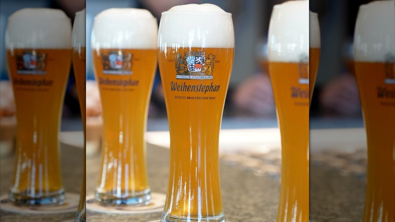 Three glasses of Weihenstephaner beer on bar.