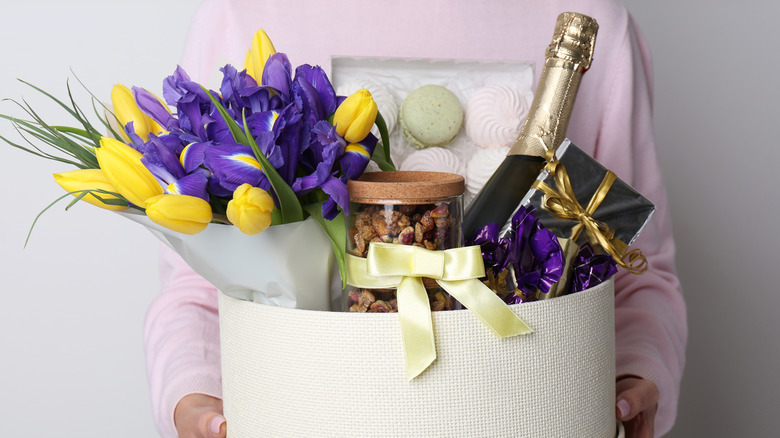 Person holding white gift basket