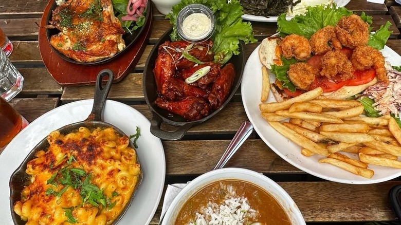 Several dishes from Peaches Hothouse served together on an outdoor table in Brooklyn.