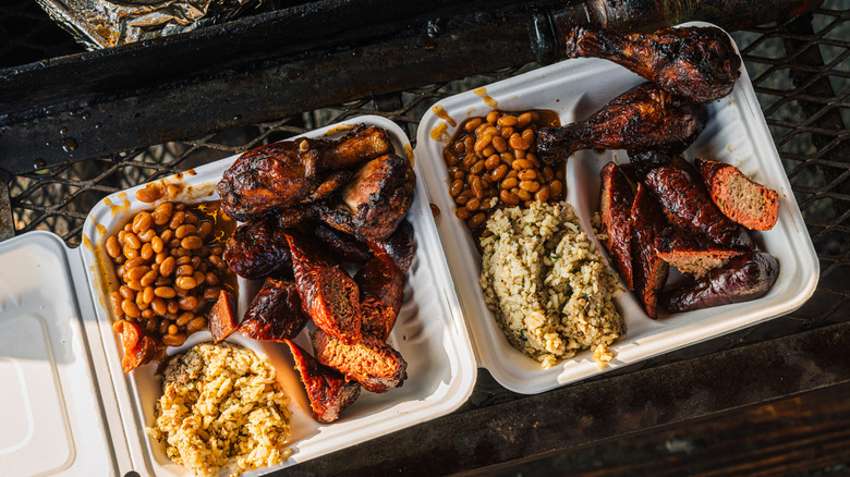 BBQ meals in containers on a metal grate