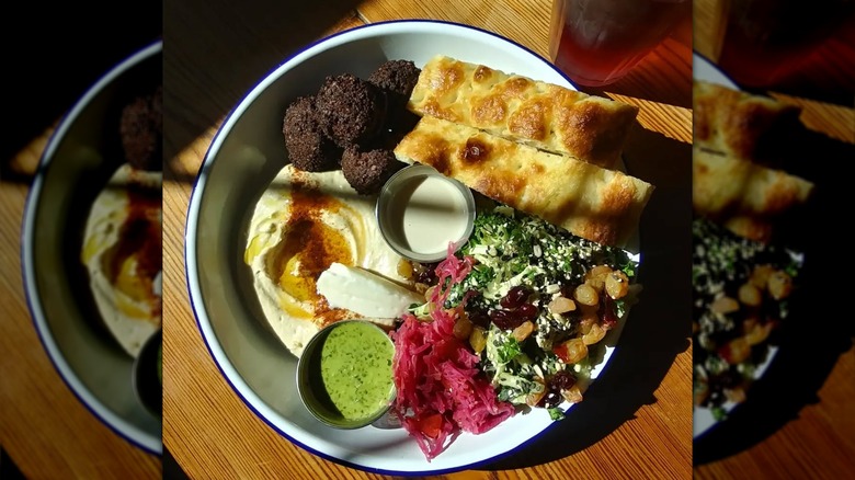 1000 Figs falafel platter with falafel, hummus, kale and cabbage salad, toum, tahini, zhoug, and fresh bread